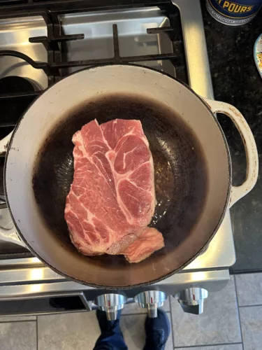 Raw pork shoulder into cast iron dutch oven